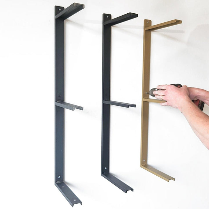 heavy-duty metal shelf brackets in clear, black, and brass powder-coat finish. Three, three shelf brackets mounted on wall by Vault Furniture