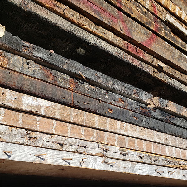 barnwood shelving before finish. reclaimed wood with nails, burn ends and plaster wall lines. materials from vault furniture.