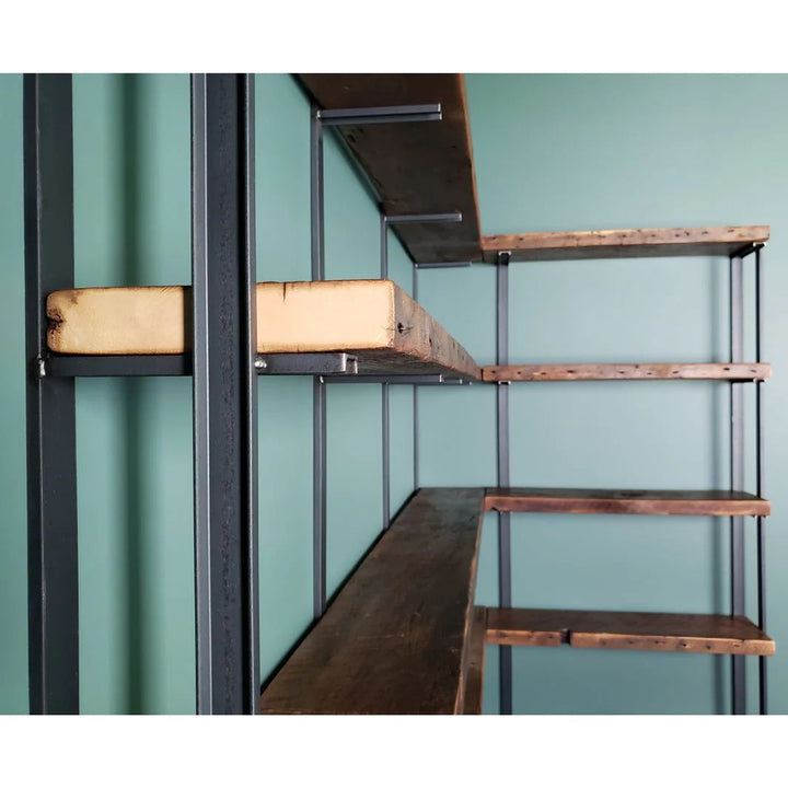 close shot of heavy duty reclaimed pine wood floating shelves and wall mounted bookshelves with steel bookend brackets.