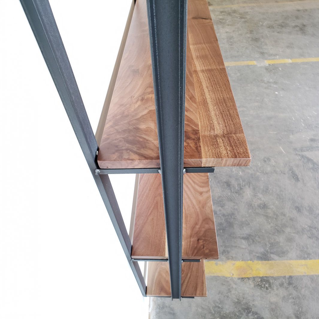 black walnut shelving unit and floating bookshelf. American steel bookend brackets that are wall mounted. 