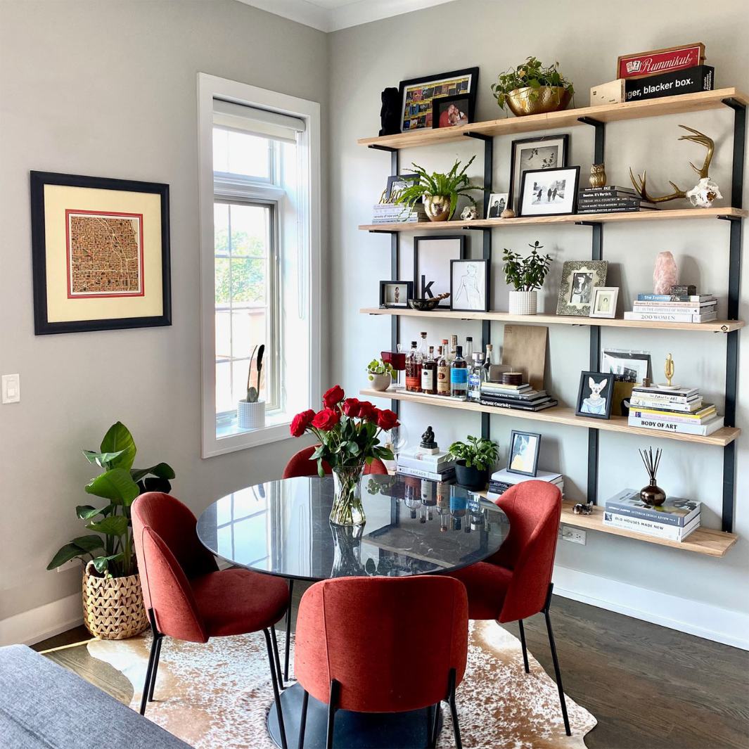 Modern mid century modern living room with wall mounted bookshelf. solid ash wood floating shelves and black steel brackets for a large heavy-duty shelving and storage unit.
