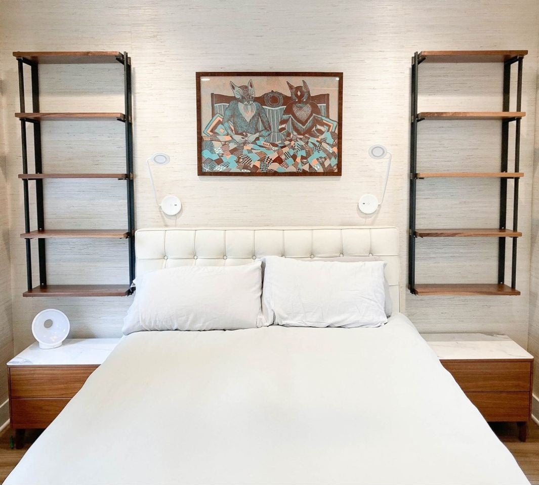 Bedroom with floating black walnut wood shelves with steel bookend brackets. 