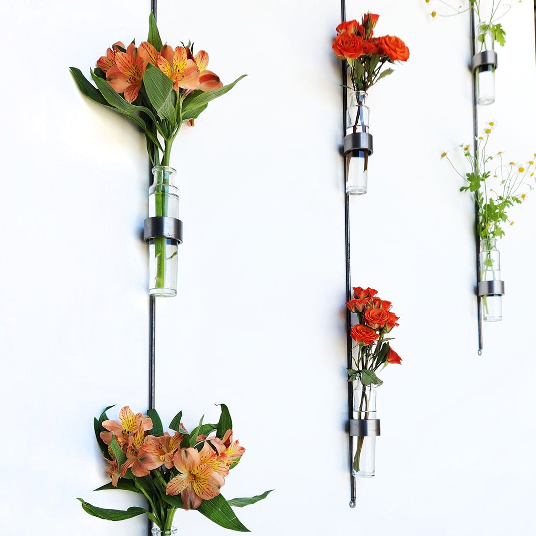 Handmade vertical wall vase with steel frame and recycled glass vials for flowers or plant cuttings