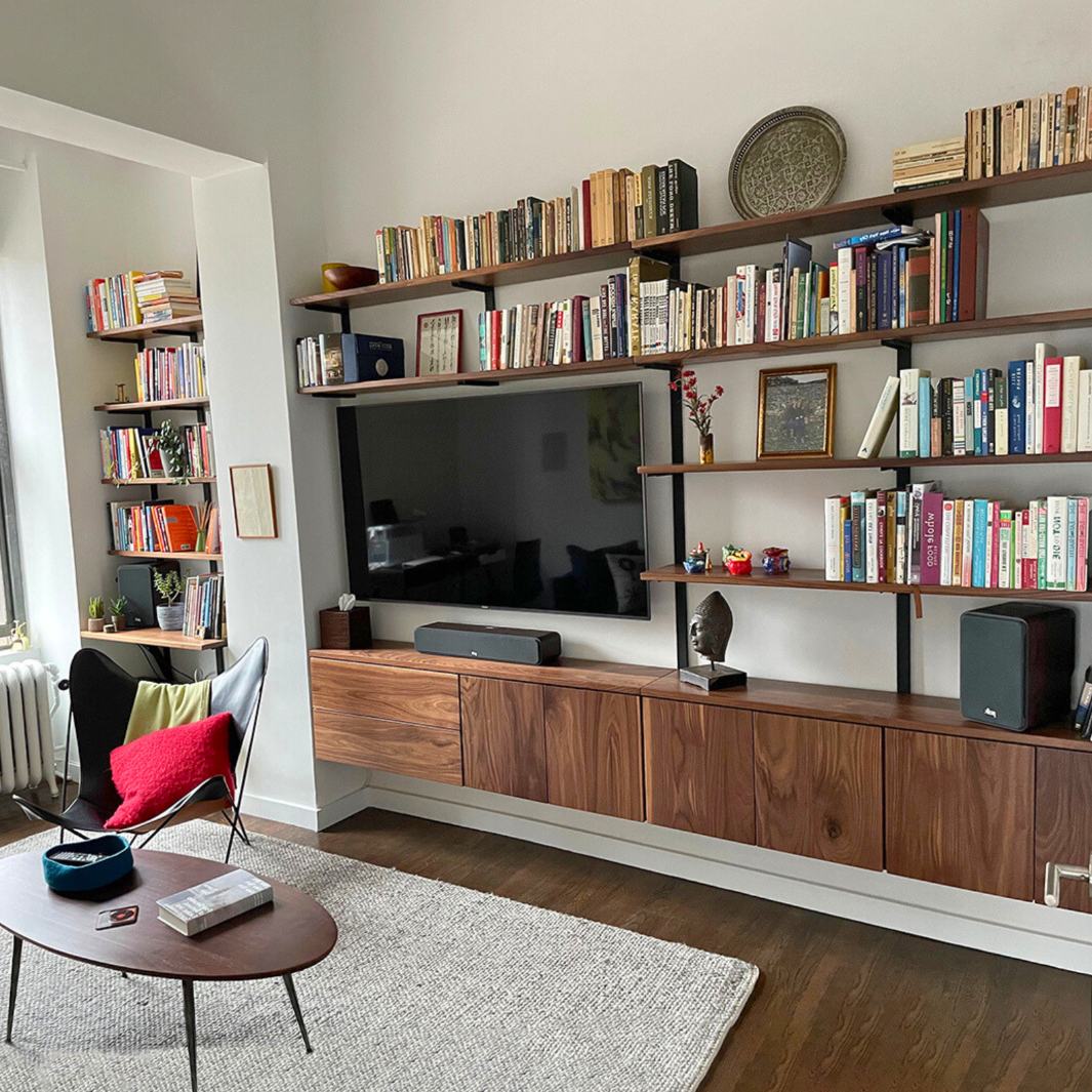 custom mid century modern floating bookshelf for storage and decor display. Solid wall mounted black walnut wood shelves and American steel brackets 