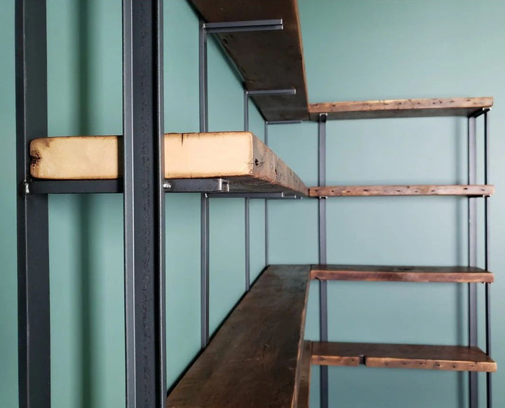 close shot of heavy duty reclaimed pine wood floating shelves and wall mounted bookshelves with steel bookend brackets.