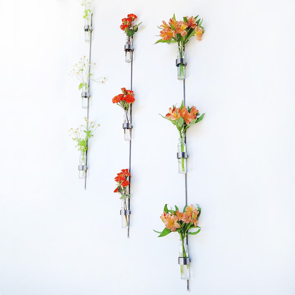 Handmade vertical wall vase with steel frame and recycled glass vials for flowers or plant cuttings