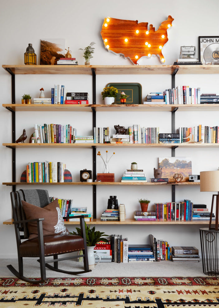 Solid Ash wood wall-mounted bookshelf with books and decorative items in a modern rustic living room.