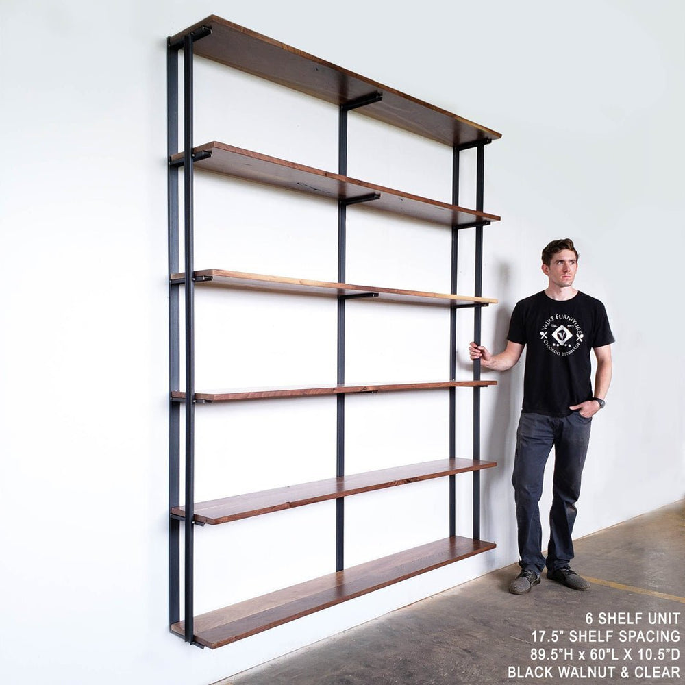 Tall wall-mount bookshelf brackets. heavy duty shelving brackets handmade in USA with solid Amercian steel with clear powder coat finish. 7ft tall shelving system by 6ft wide, solid black walnut shelves. Outside shelf brackets have bookend detail. Vault Furniture