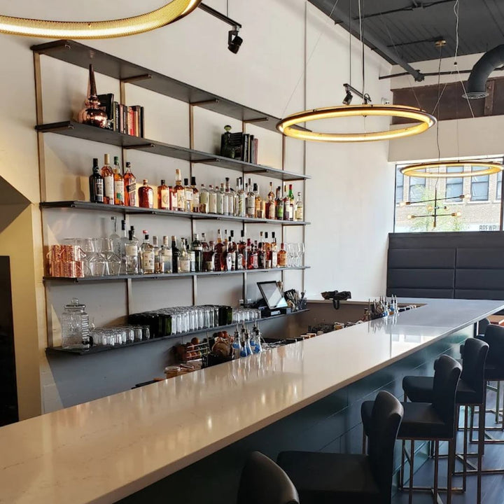 Modern bar with heavy-duty solid wood floating shelves stocked for storage and display.